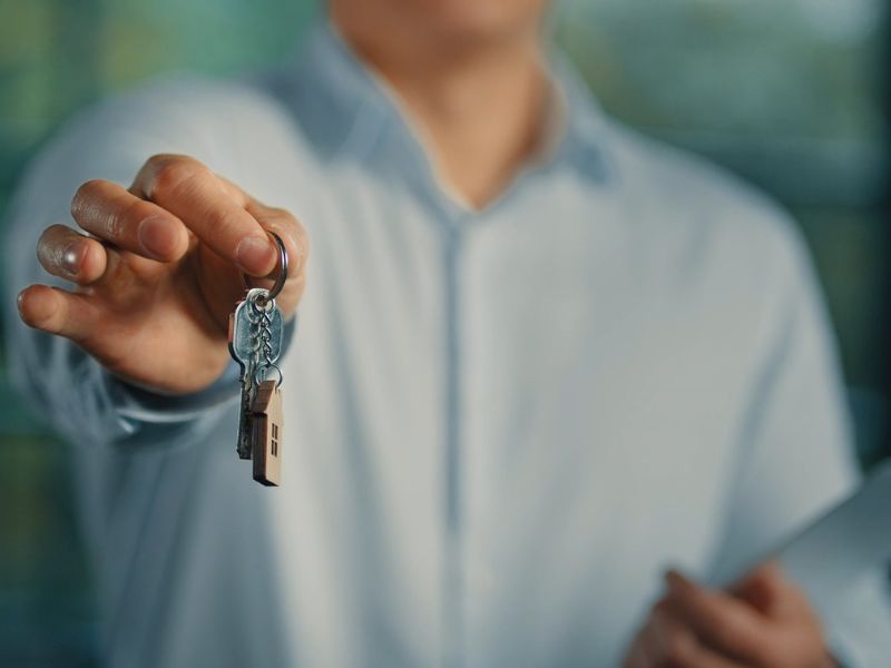 čovek drži ključ i rešenje o legalizaciji stana u ruci